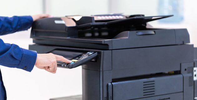 Photo d'une main utilisant une imprimante multifonction